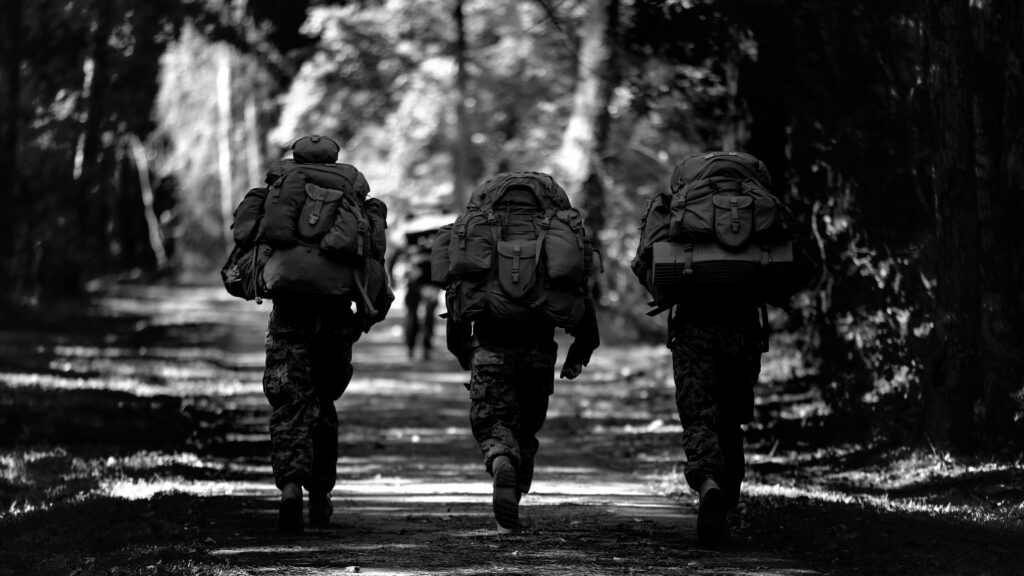 three soldiers rucking trail